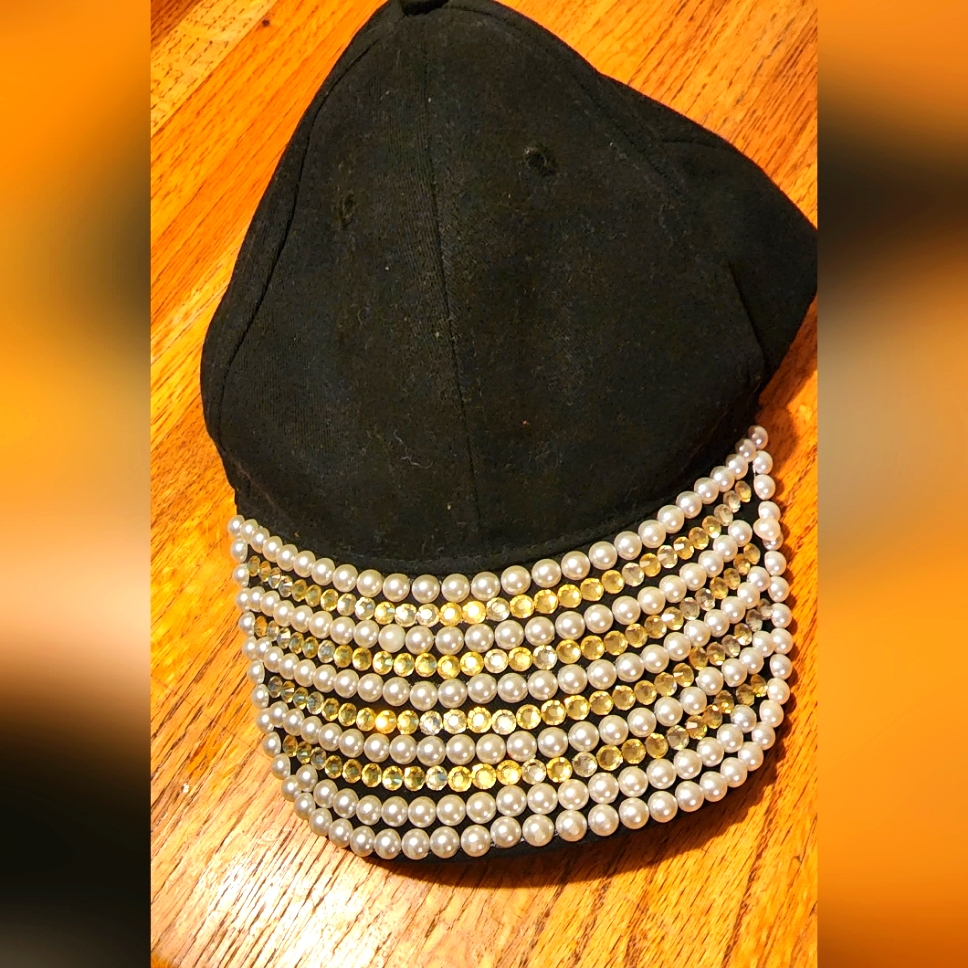 A Black Hat With Diamonds And Pearls On It.